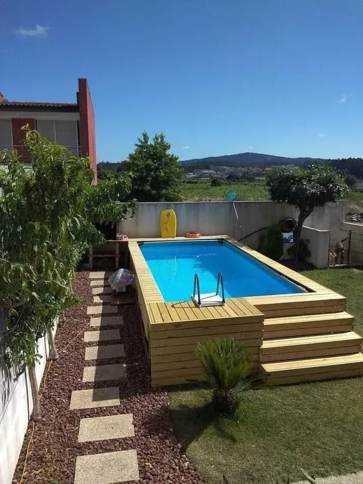 Piscina rectangular terminada con deck de madera en un patio residencial
