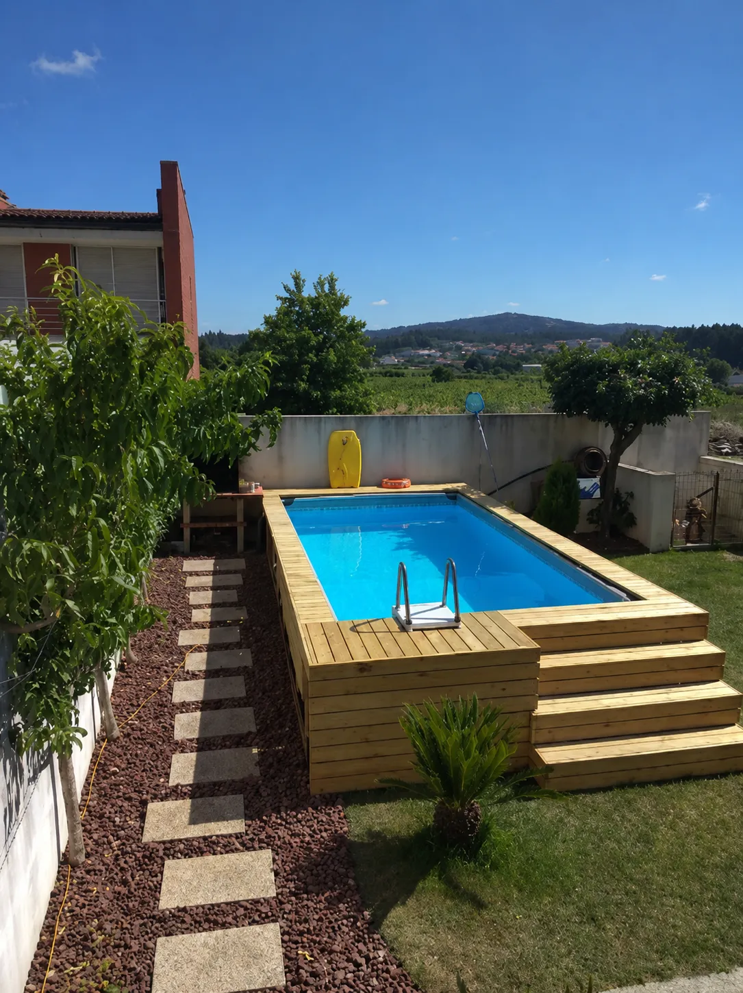 Piscina de fibra terminada con deck de madera en el patio de una casa