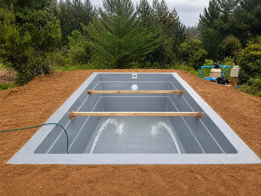 Piscina de fibra gris en prueba de agua durante su instalación